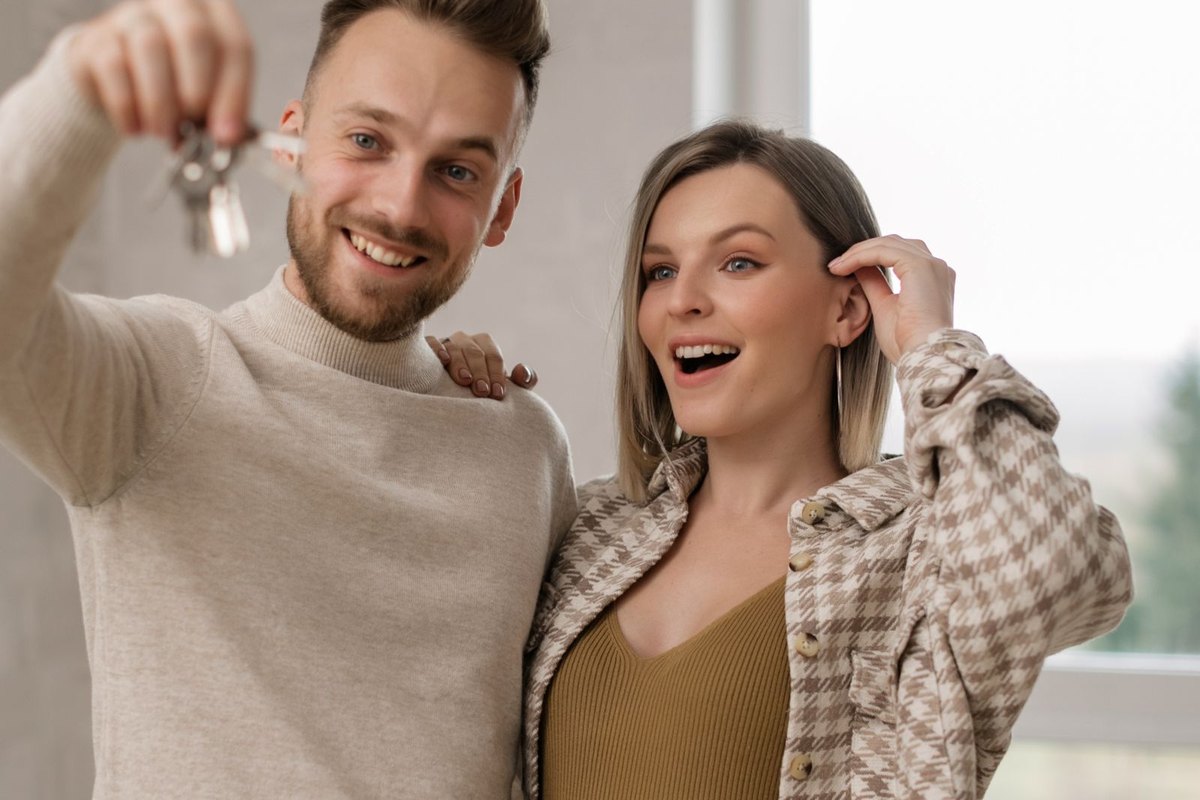 A couple holding up the keys to their new home