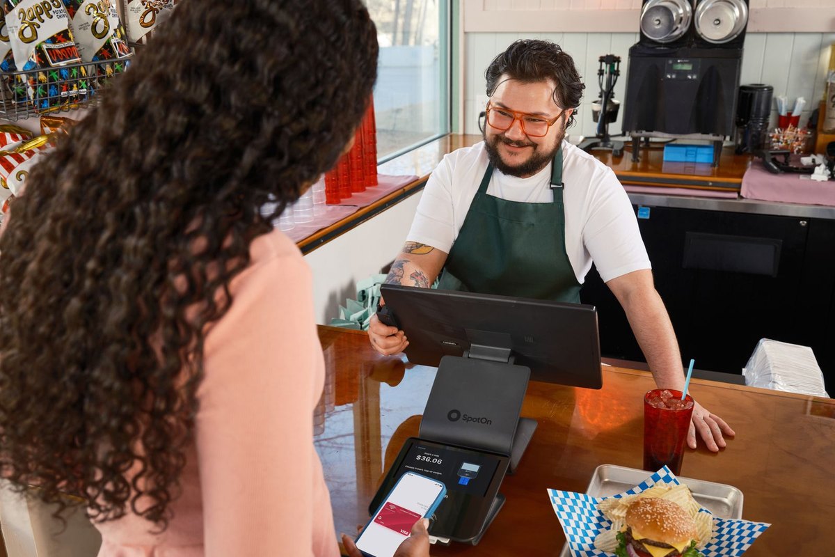 A customer paying contactless at a café counter