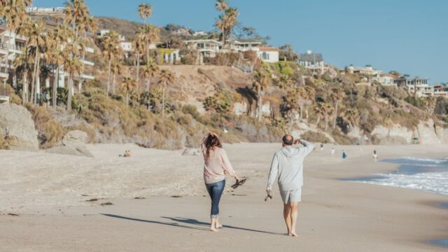 A mature couple walking along a sunny beach
