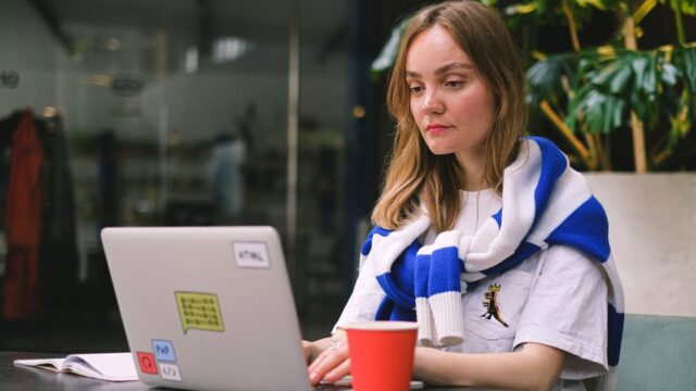 A woman working on a laptop in a café