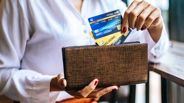 A woman taking a card out of her wallet in a café