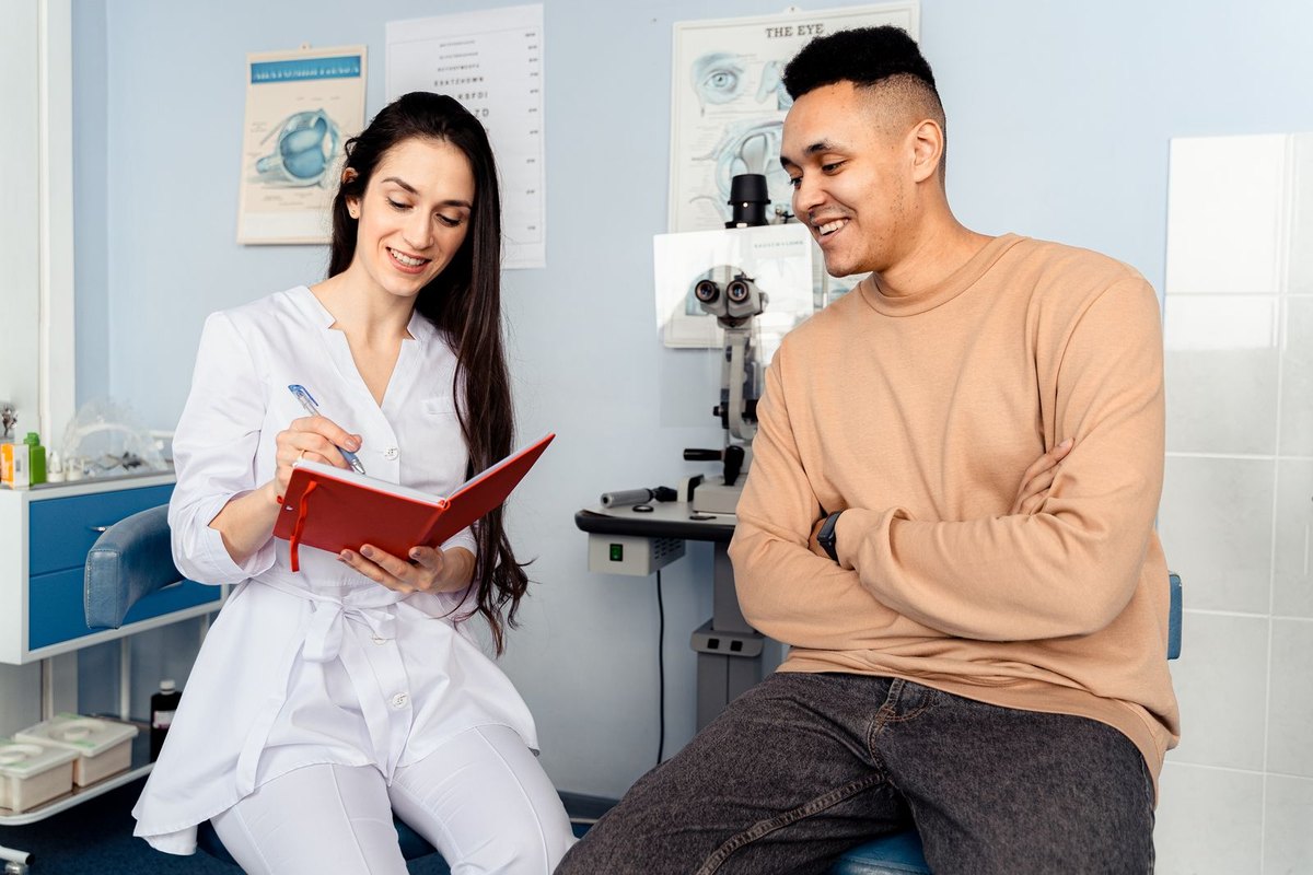 A patient talking with an eye doctor during an appointment at a clinic