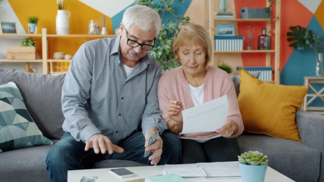 An older couple going through paperwork together in their living room
